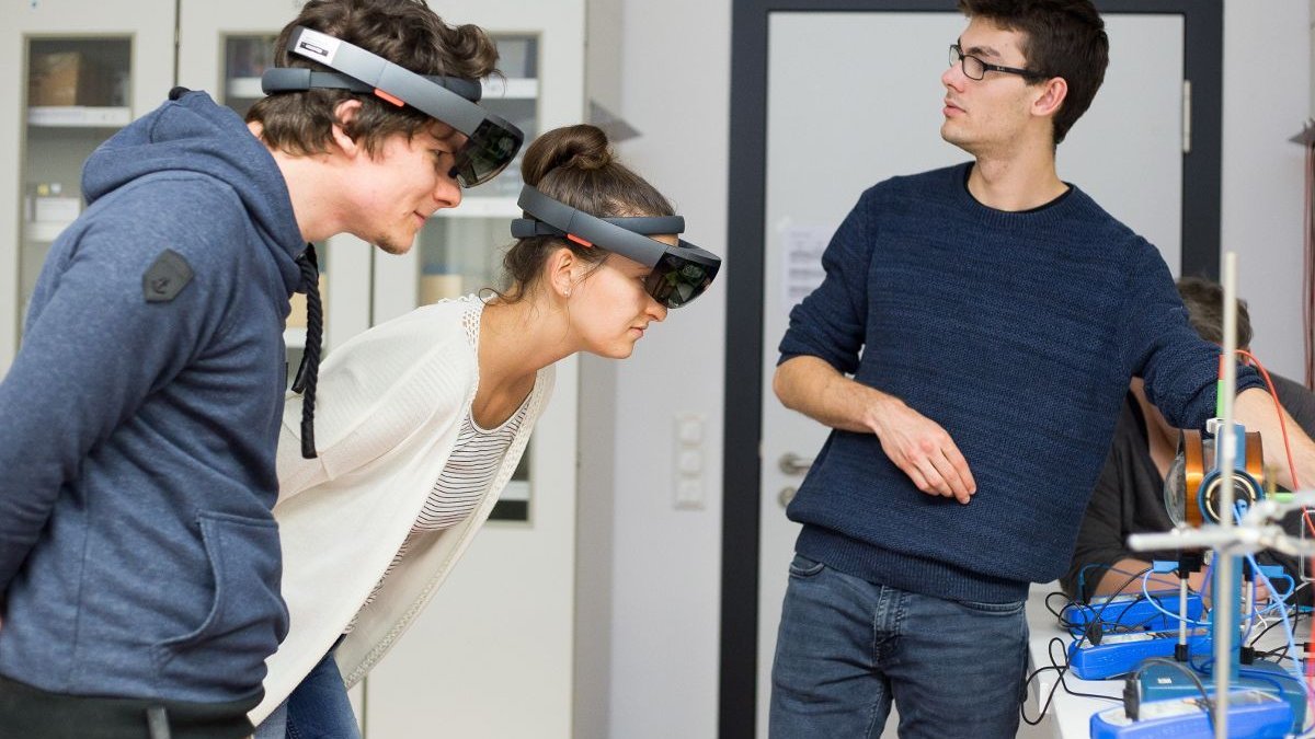 Lerngruppe mit Augmented-Reality-Brillen an einem Physikexperiment
