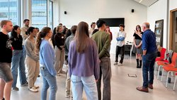 Ein Mann erklärt einer Gruppe junger Leute etwas