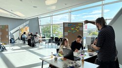 Personengruppe bei einer Workshopzusammenfassung vor Flipcharts
