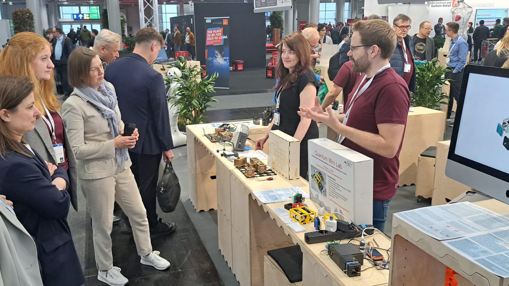 Personengruppe im Gespräch auf der Hannover Messe an einem Stand