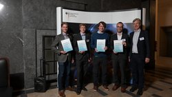 Gruppenbild der Gewinner mit einem Vertreter des Ministeriums