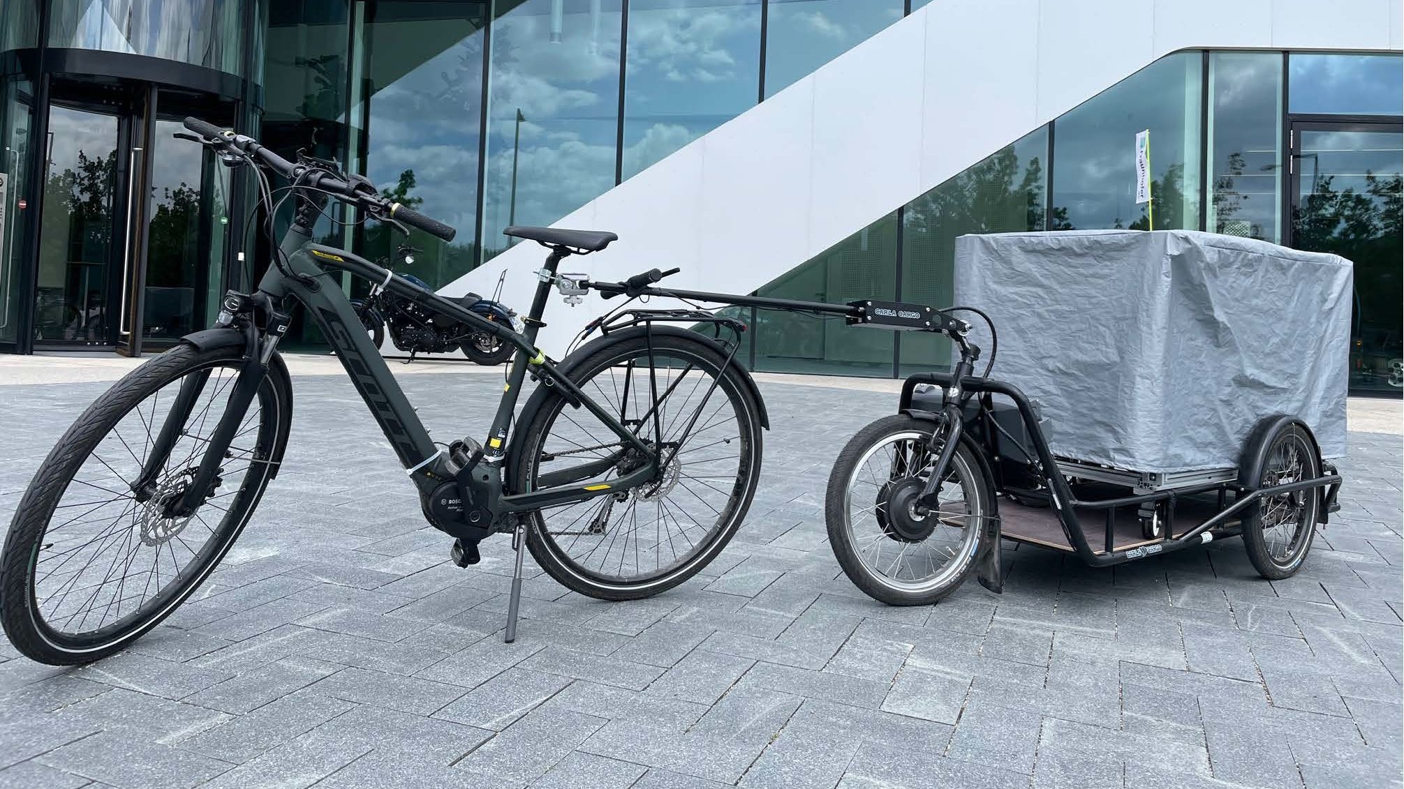 Ein Fahrrad mit Anhänger der das "Mobile Lab" beinhaltet 
