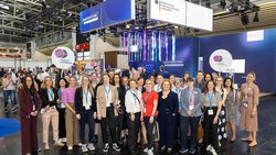Gruppenbild der Innovation Journey „Leading Women in Quantum“ vor dem BMFTR-Messestand