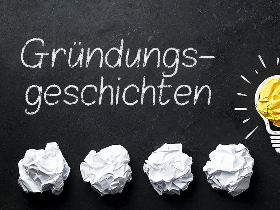 Symbolbild Gründung - Glühbirne, zerknüllte Papiere und Schriftzug Gründungsgeschichten