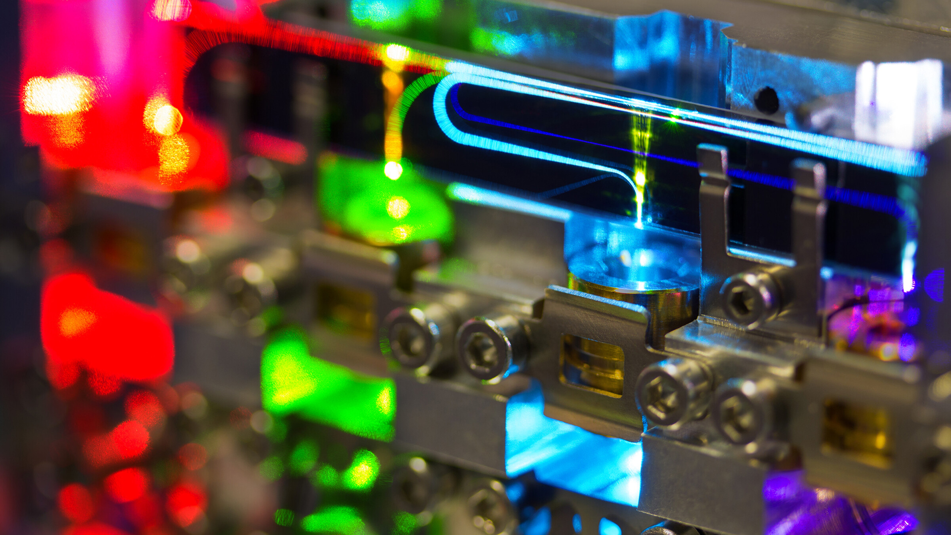Nahaufnahme eines silbernen, metallischen Geräts mit buntem Laserlicht